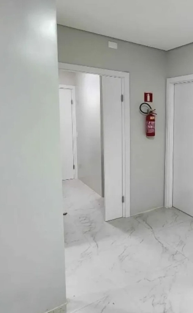 Corredor limpo após a obra com extintor instalado