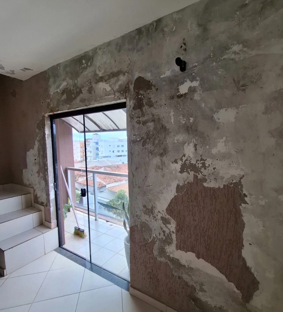 Antes da pintura interna: parede com reboco danificado, infiltrações e descascamento