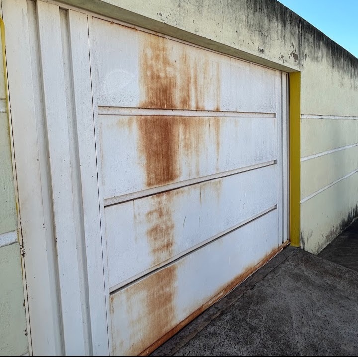 Antes da restauração: portão metálico branco com ferrugem e oxidação aparente
